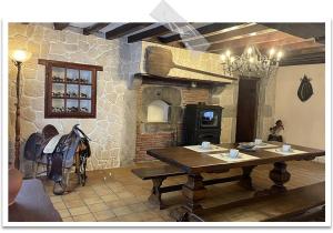 a room with a wooden table and a brick oven at Gîte Le Pont du Soleil in Hyds