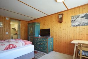 a bedroom with a bed and a tv on a cabinet at Studio bim Chalet bim Chilchli in Mürren