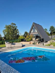 a swimming pool with a house in the background at Nikis House Luxury Pool - Spa Villa in Ba°evac
