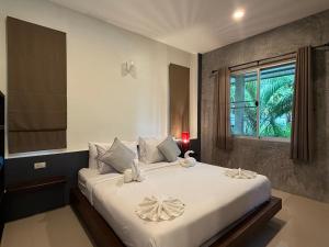a bedroom with a large white bed with a window at The Rinya Hotel Koh Phangan in Thong Sala +64 photos