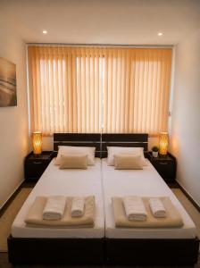 a bedroom with a large bed with two pillows at Хотел Свети Димитър in Sozopol