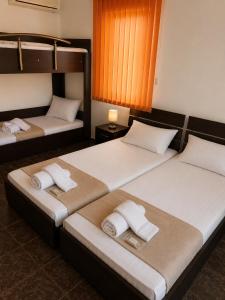 two beds in a hotel room with towels on them at Хотел Свети Димитър in Sozopol