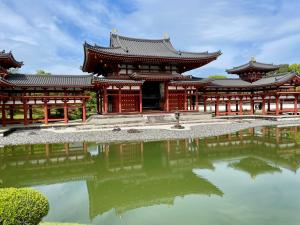 a temple with a pond in front of it at サニーサイドホステル2号館 in Uji