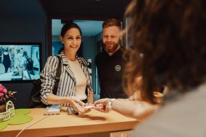 a woman shaking hands with a man at a counter at VIER Studios & Restaurant in Längenfeld +145 photos