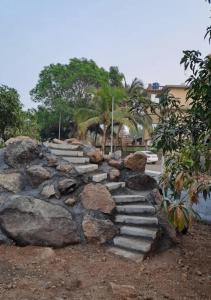 a stone path in a yard with rocks and trees at Krishna Garden and Resort in Betgaon
