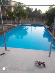 a blue swimming pool with a person laying next to it at Krishna Garden and Resort in Betgaon