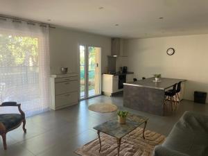 a living room with a table and a kitchen at Apartment 65 m2 NE Rez de Jardin 2 chambres in Varetz