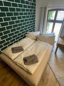 a bed with two pillows and a brick wall at Jagdstube in Prezelle