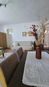 a living room with a couch and a vase with flowers at Apartman Marija in Zlatibor