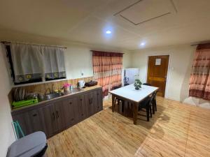 a kitchen with a table and a dining room at Ezzy Air B&B in Salelologa