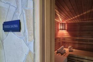 a bathroom with a sauna with a sign on the wall at Rezidence VOGELSANG in Kašperské Hory +118 photos