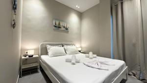 a bedroom with a white bed with a white bedspread at Magdalena Elegant Studios in Neoi Epivates