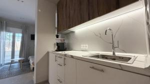 a kitchen with a sink in a white kitchen at Magdalena Elegant Studios in Neoi Epivates +26 photos