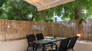 a black table and chairs in front of a fence at Magdalena Elegant Studios in Neoi Epivates