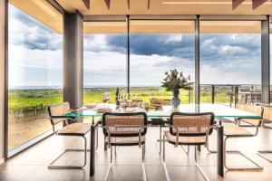 a dining room with a table and chairs and large windows at Feudo Antico in Tollo