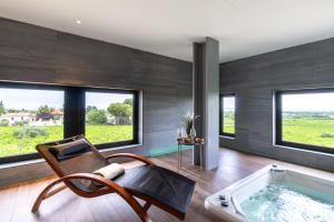 a room with a tub and a chair and windows at Feudo Antico in Tollo