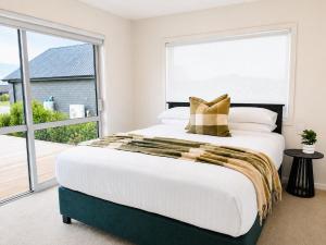 a bedroom with a large bed and a large window at The Burnby in Te Anau
