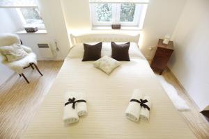 1 dormitorio con 1 cama grande y zapatillas. en Allegro Exclusive Suites Old Town Center, en Zadar