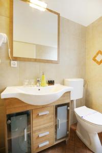 Un baño con lavabo, inodoro y espejo. en Allegro Exclusive Suites Old Town Center, en Zadar