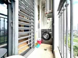 a laundry room with a washer and a washing machine at Cozy Skyline Escape 2Bedroom Near Hanoi Major Business District in Hanoi