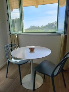 a white table and two chairs in front of a window at Bed and Breakfast Casa Tortia in Cocconato