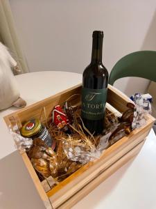 a bottle of wine in a wooden crate with snacks at Bed and Breakfast Casa Tortia in Cocconato +14 photos