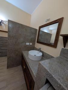 a bathroom with a sink and a mirror at Thamani Apartment Zanzibar in Pwani Mchangani