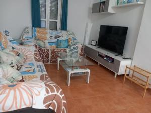 a living room with a couch and a flat screen tv at Relax Pinares in Lepe