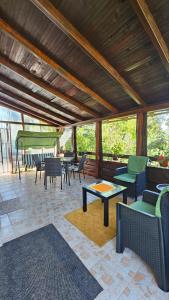 a covered patio with chairs and tables and a swing at Apartman Marija in Zlatibor