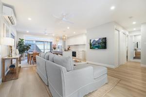 a living room with a white couch and a table at Basalt Beach House in Bargara