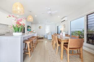 a kitchen and dining room with a table and chairs at Basalt Beach House in Bargara