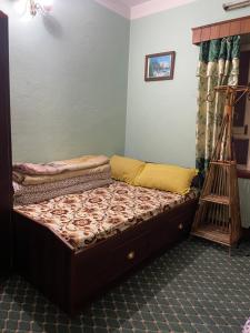 a small bed in a room with a bed frame at Patan Nest in Pātan