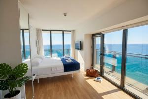 a bedroom with a bed and a view of the ocean at Batumi Sky Palace in Batumi