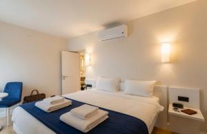a bedroom with a large white bed with towels on it at Batumi Sky Palace in Batumi