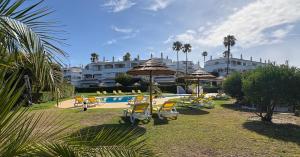 a resort with a swimming pool with chairs and umbrellas at Casa Primavera in Carvoeiro