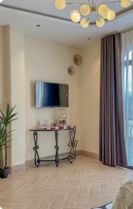 a living room with a table with a tv on the wall at Homestay Beauty D1 in Ho Chi Minh City