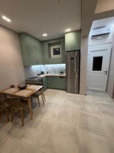 a kitchen with green cabinets and a wooden table at HOME stay in Itea