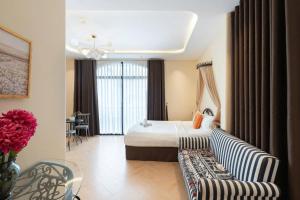 a hotel room with a bed and a couch at Homestay Beauty D1 in Ho Chi Minh City