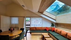 a living room with a couch and a table at central sky-penthouse with iconic matterhorn view in Zermatt +19 photos