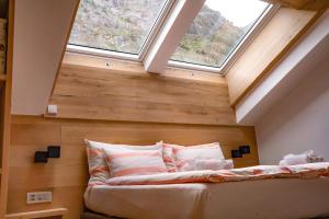 a bed in a room with two windows at central sky-penthouse with iconic matterhorn view in Zermatt