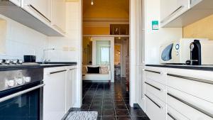 a kitchen with white cabinets and a black tile floor at I mille Tramonti di Ilaria in Livorno