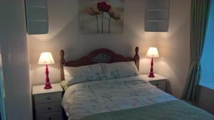 a bedroom with a bed and two lamps on night stands at Barnkirk Holidays in Newton Stewart +10 photos