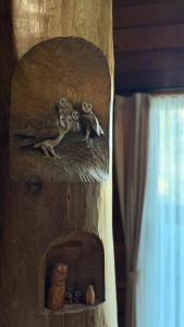 a wooden shelf with two owls on it at ログbase in Kaga