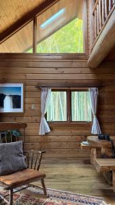 a room with wooden walls and windows in a cabin at ログbase in Kaga