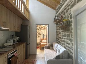 a kitchen with a couch and a brick wall at Stone House in Këlcyrë