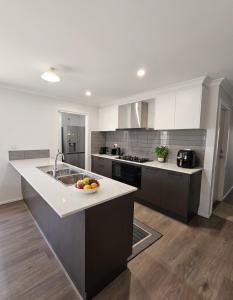 a kitchen with a bowl of fruit on a counter at St Germain House, Clyde North in Clyde North