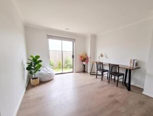 an empty living room with a table and chairs at St Germain House, Clyde North in Clyde North