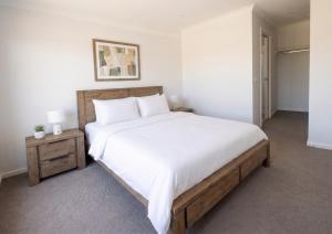a bedroom with a large bed with white sheets and pillows at St Germain House, Clyde North in Clyde North