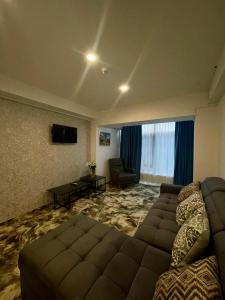 a large living room with a couch and a television at Hotel Sallaris Monteoru in Sărata-Monteoru