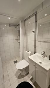 a white bathroom with a toilet and a sink at Spacious villa in Sörby in Gävle +14 photos